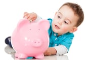 Boy saving money in a piggybank - isolated over a white background